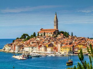 Rovinj in Kroatië, kleurrijke kustplaats op een heuvel met grote kerk, klokkentoren en haven vol boten