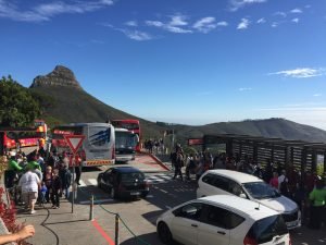 Uitzicht op de Lion’s Head-berg vanaf een druk parkeerterrein met bussen, auto’s en toeristen op een zonnige dag in Zuid-Afrika