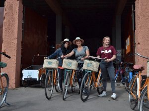 Drie lachende vrouwen staan met fietsen met mandjes voorop in Marokko.
