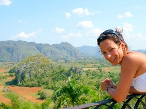 Lachende vrouw met uitzicht over groene valleien en karakteristieke heuvels bij Viñales in Cuba