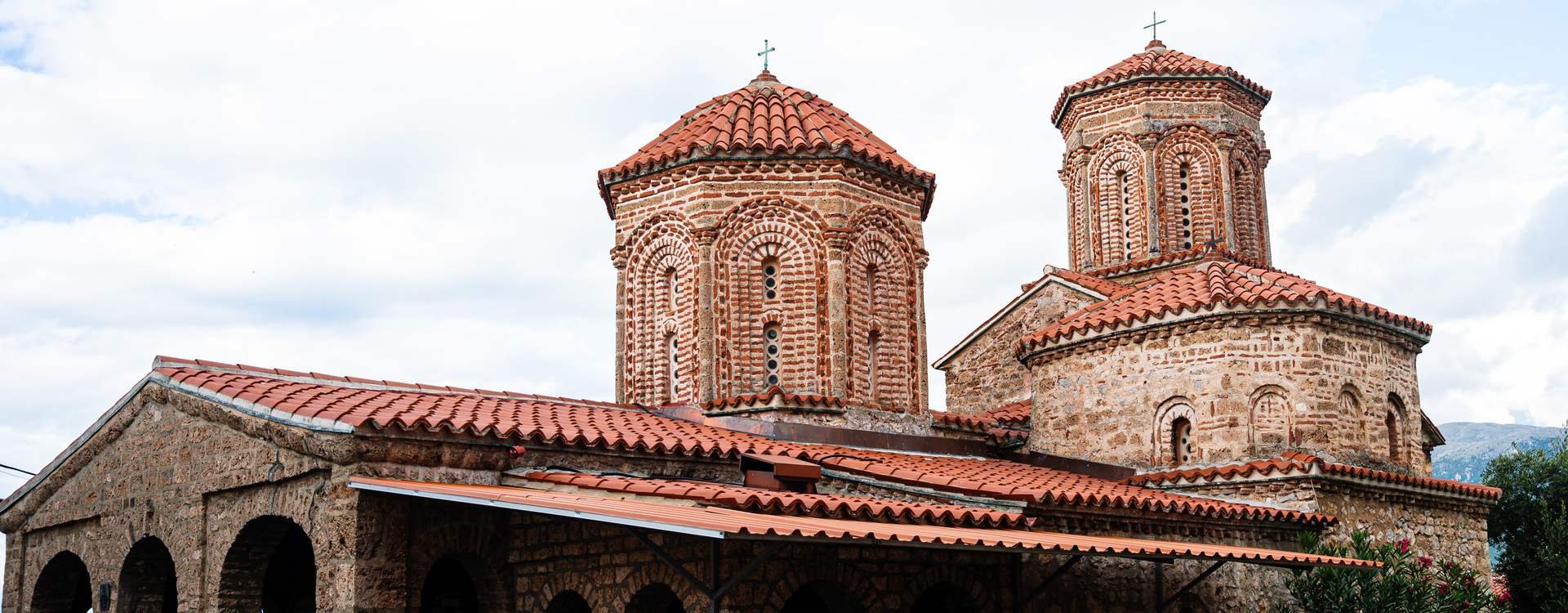 Historische stenen kerk in Ohrid in Noord-Macedonië met rode pannendaken en twee koepeltorens met kruisen