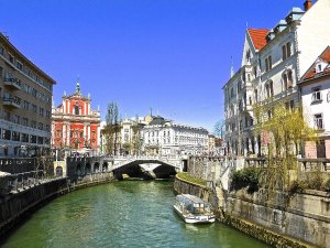 Rivier door een Europese stad met historische gebouwen, brug en boot op het water in Kroatië