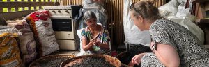 Lokale vrouw toont een reiziger hoe thee met de hand wordt gesorteerd in een traditionele werkruimte.