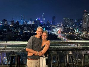 Een man en een vrouw staan voor de skyline van Ho Chi Minhstad.