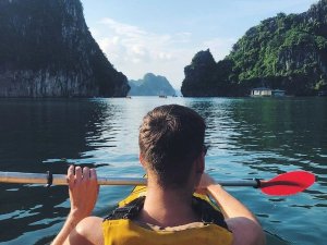 Reiziger zit in kayak in Halong Bay
