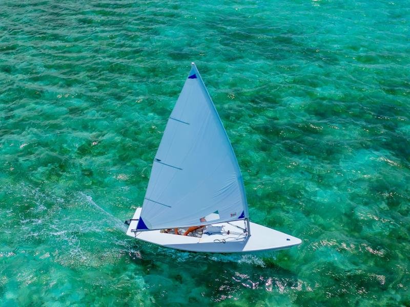 Luchtfoto van een witte zeilboot op helder turquoise water bij de kust van Cuba