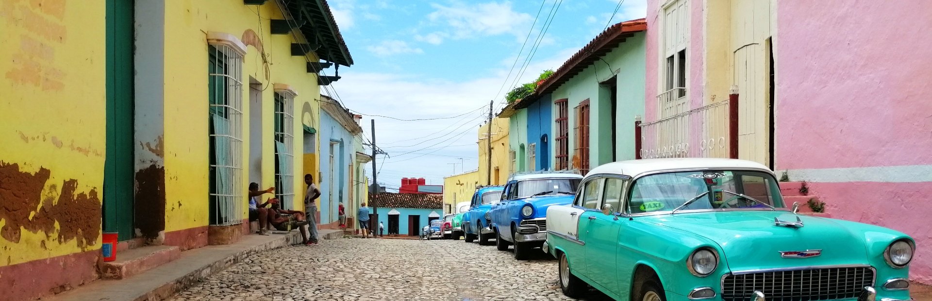 Levendige Cubaanse straat met kleurrijke gebouwen en klassieke auto’s