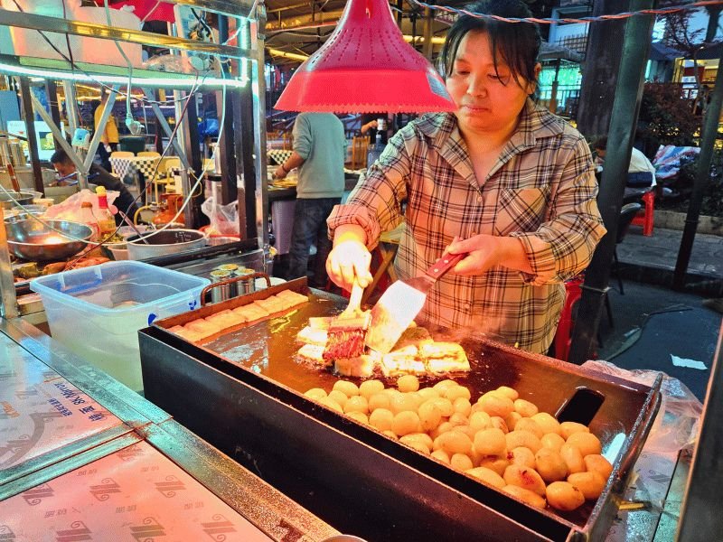 Vrouw bereidt eten in foodstand