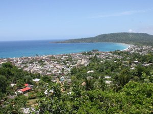 Kustplaats aan een blauwe baai omringd door groene heuvels in Baracoa Cuba