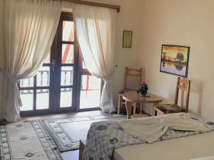 Hotelkamer bij het Ohridmeer in Noord-Macedonië met bed, balkon en lichte gordijnen