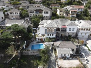 Luchtfoto van Gjirokastër in Albanië met traditionele huizen, grijze daken en een zwembad tussen de gebouwen