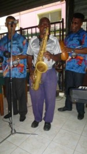 Drie mannen spelen muziek met een saxofoon en twee percussie-instrumenten in Cuba