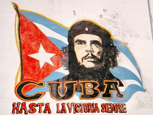 Muurschildering van Che Guevara met de Cubaanse vlag en de tekst CUBA en HASTA LA VICTORIA SIEMPRE in Cuba