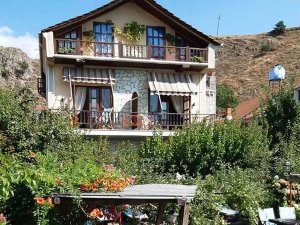 Pension bij het Ohridmeer in Noord-Macedonië met balkon, tuin vol bloemen en uitzicht op heuvels