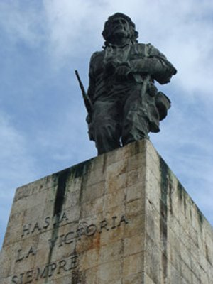 Bronzen standbeeld van Che Guevara met geweer in de hand op een stenen sokkel met de tekst Hasta la Victoria Siempre in Cuba