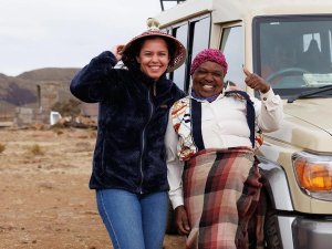 Vrouw met een local naast een auto in Transkei, Zuid-Afrika