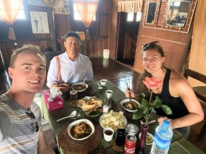 Reizigers aan het eten met lokale man in Myanmar