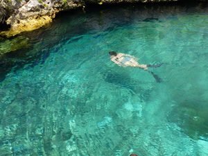 Persoon snorkelt in helder turquoise water langs een rotsachtige kust bij Varadero in Cuba