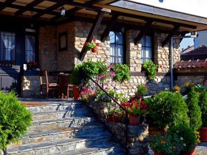 Sfeervol terras bij een traditioneel hotel met stenen gevel en kleurrijke bloemen in Bitola in Noord-Macedonië