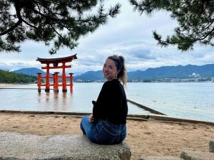 Nicky zittend bij de rode poort in het water bij Miyajima