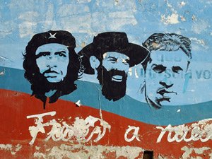 Verweerde stencil muurschildering met portretten van Che Guevara en Fidel Castro op een blauw rode muur in Havana Cuba