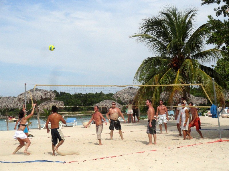 Een groep speelt beachvolleybal op een zonnig tropisch strand in Cuba