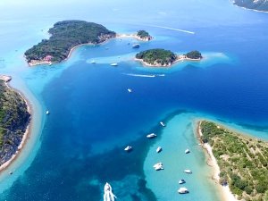 Luchtfoto van groene eilanden en schiereilanden in helderblauw en turquoise water met vele boten in Kroatië