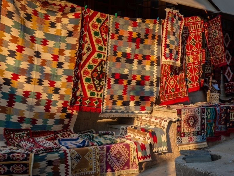 kleurrijke patronen op tapijten en textiel uitgestald op markt in Gjirokastër Albanië