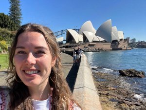 Lachende vrouw maakt een selfie met het Sydney Opera House en de Harbour Bridge op de achtergrond in Sydney, Australië