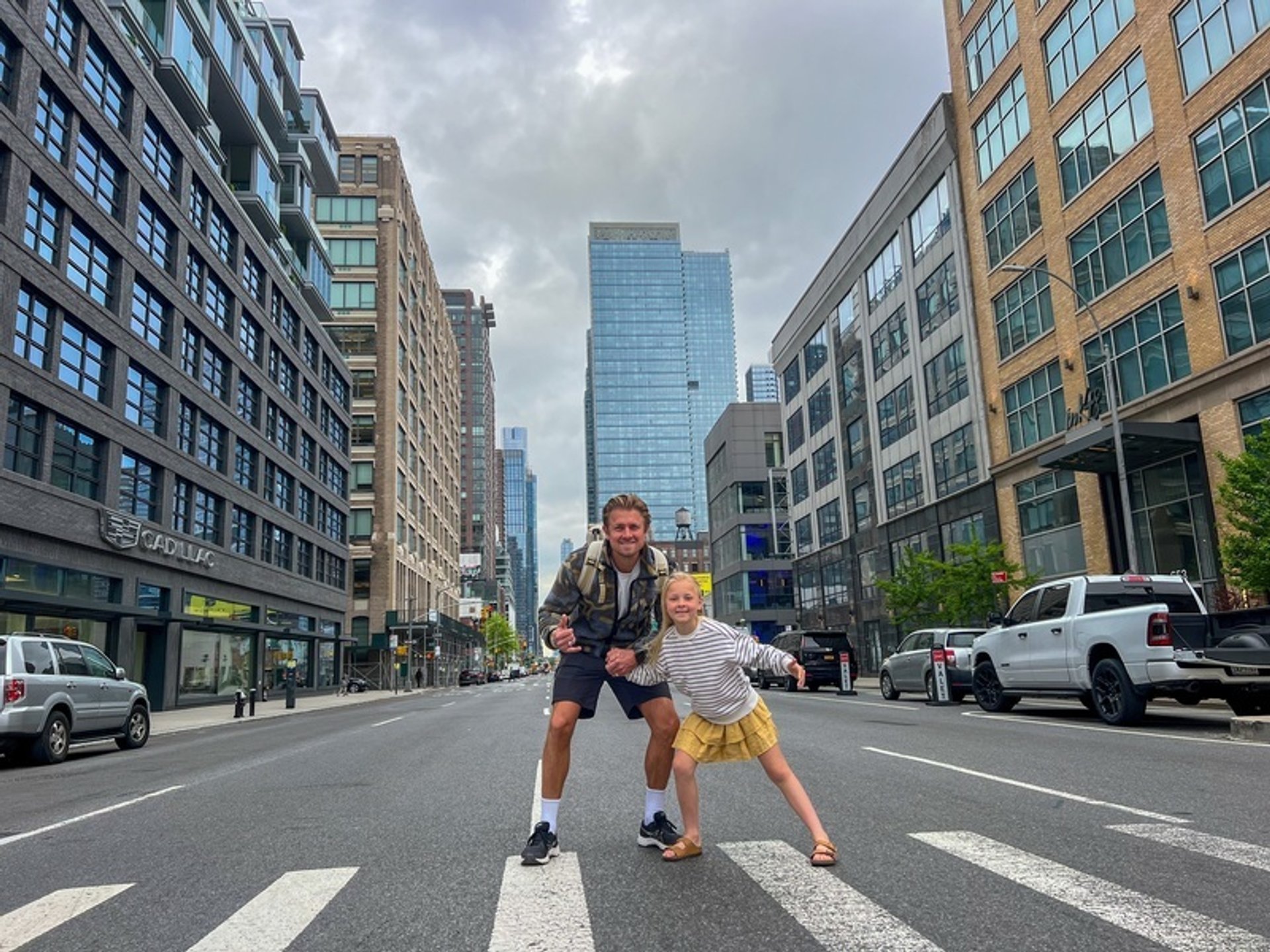Een man en een jong meisje poseren midden op een stadsstraat, omringd door hoge gebouwen in New York, Verenigde Staten.