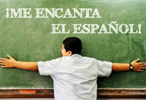 Kind met gespreide armen voor schoolbord met tekst Me encanta el español in klaslokaal in Havana Cuba