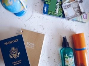Flat lay van reisbenodigdheden met Amerikaans paspoort, vreemde valuta, wereldbol, reisgidsen en zonnebescherming in Cuba