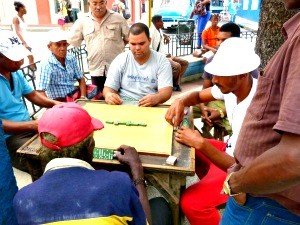 Groep mannen speelt domino aan een buitentafel in Cuba