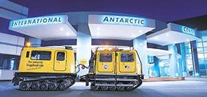 Twee gele Hägglund rupsvoertuigen staan geparkeerd buiten het verlichte International Antarctic Centre in Christchurch Nieuw-Zeeland