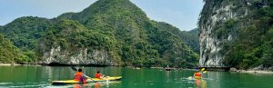 Kayakkers varen tussen de karstbergen van Halong Bay