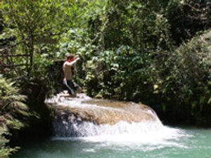 Man springt vanaf een kleine waterval in een natuurlijke poel in Topes de Collantes Cuba