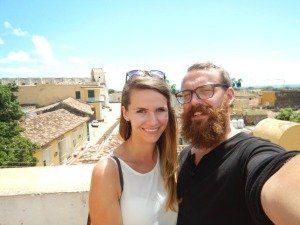 Lachende man met baard en bril en lachende vrouw maken een selfie met een oude stad op de achtergrond in Cuba