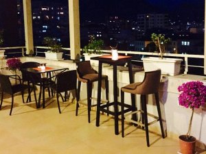 Sfeervol dakterras met zitplaatsen en kaarsen, met uitzicht op de stad bij avond in Tirana in Albanië