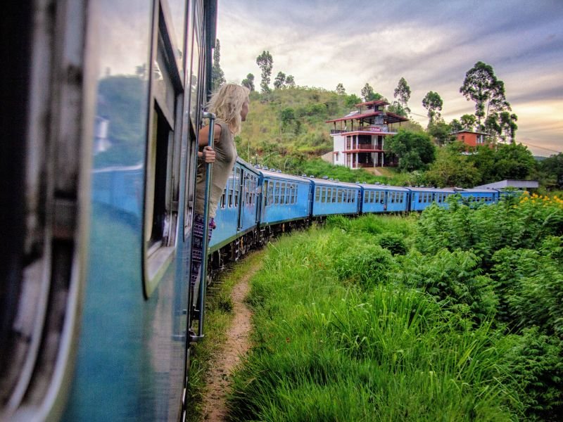 vrouw hangend uit trein in natuur van Sri Lanka