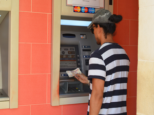 Man pint geld bij een geldautomaat op straat in Cuba
