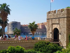 Uitzicht op de historische stenen stadspoort, brug, oude haven en vesting van Dubrovnik onder een blauwe lucht in Kroatië