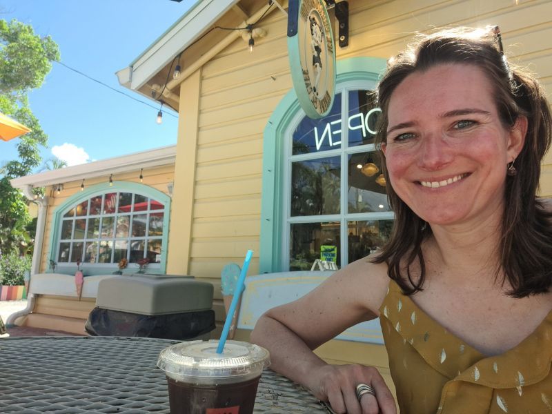 reiziger met ijskoffie voor een kleurrijk koffiezaakje op Captiva Island