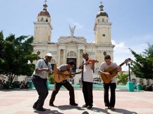 Vier muzikanten spelen muziek op een plein voor een grote kerk in Trinidad Cuba